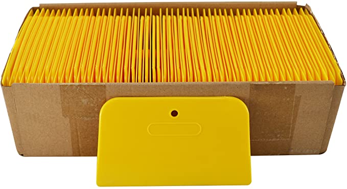Ye/ow plastic spreader – flexible applicator for body fi/er and glazing in vehicle repair.