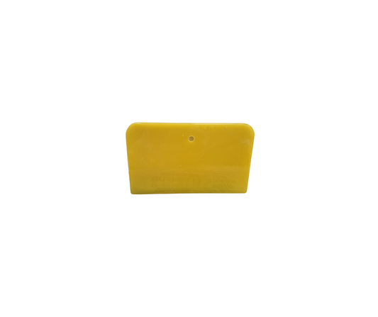 Single yellow 3x6 inch plastic spreader with a hang hole, used for applying body filler or putty, shown against a white background.
